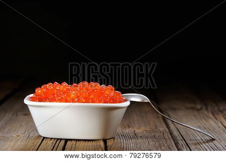 Red Caviar In White Bowl With Silver Spoon