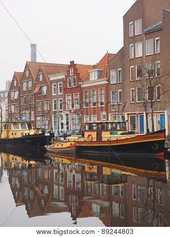 Canal with colorful boats amidst residential housing