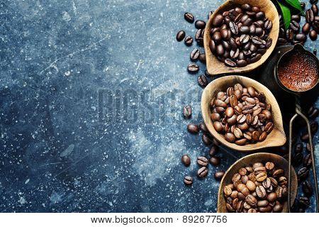 Top view of three different varieties of coffee beans on dark vintage background