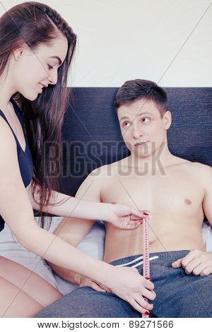 Woman Looking And Holding Tape Meter For Measure And Imagines The Desired Size Of Male