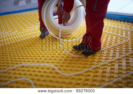 grouo of workera installing underfloor heating and colling in modern home