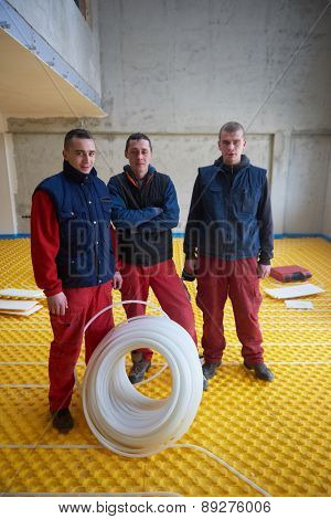 grouo of workera installing underfloor heating and colling in modern home