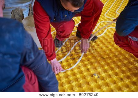 group of workera installing underfloor heating and colling in modern home