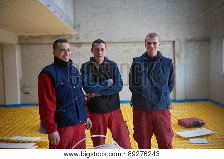 grouo of workera installing underfloor heating and colling in modern home