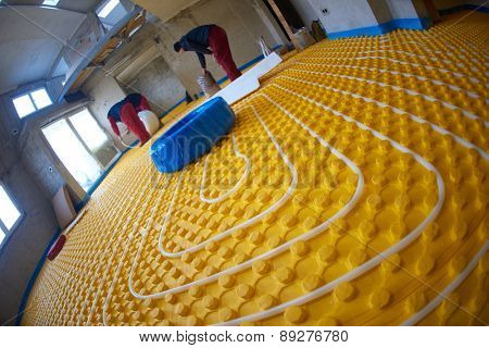 grouo of workera installing underfloor heating and colling in modern home