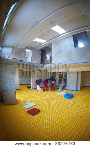 grouo of workera installing underfloor heating and colling in modern home