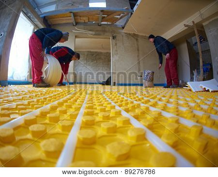 group of workera installing underfloor heating and colling in modern home
