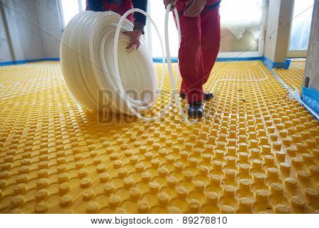 group of workers installing underfloor heating and colling in modern home