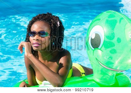Girls in swimming pool water with inflatable anmimal