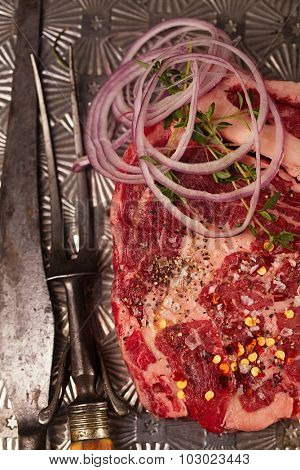beef steak t-bone with vintage meat fork on metal backdrop
