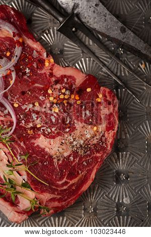 beef steak t-bone with vintage meat fork on metal backdrop