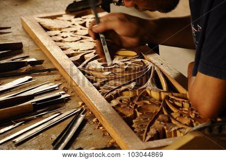 Skilled craftsman doing wood carving using traditional method