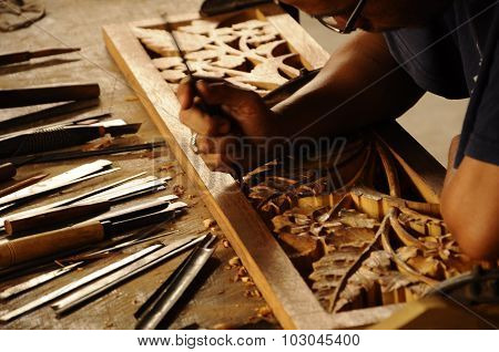 Skilled craftsman doing wood carving using traditional method