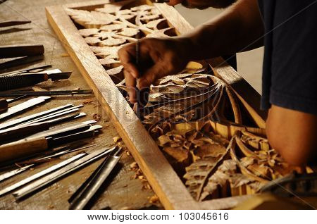 Skilled craftsman doing wood carving using traditional method