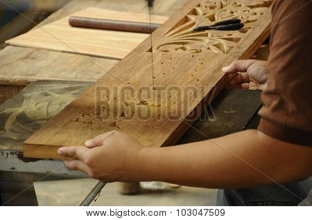 Skilled craftsman doing wood carving using traditional method