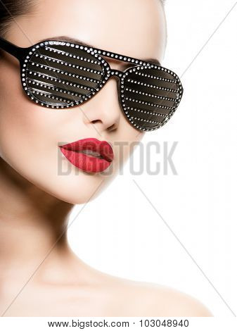 Fashion portrait of  woman wearing black sunglasses with diamonds and red lips