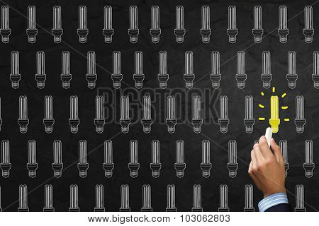 Close up of hand darwing light bulb with marker
