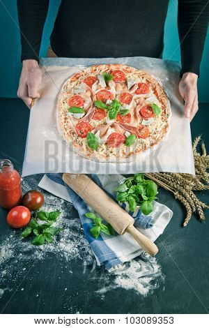 Closeup hand of baker making pizza at kitchen