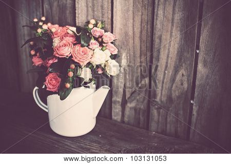 Bouquet of roses in vintage coffee pot