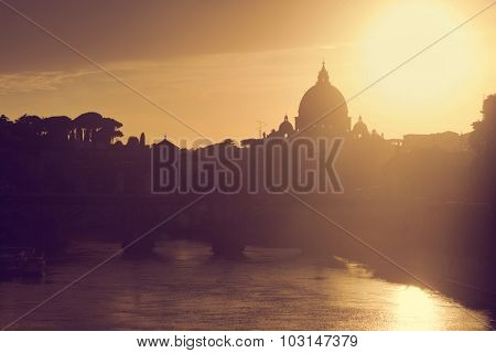 St. Peter's Basilica in Vatican City and Ponte Sant'Angelo bridge over Tiber river in Rome, Italy at sunset. Deem light
