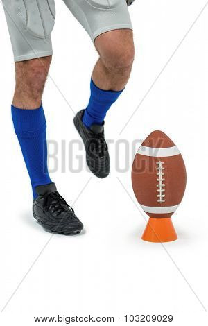 Low section of sports player being about to kick ball against white background