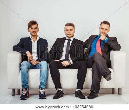 Team Of Three Businessmens Sitting On Couch, Isolated On White Background