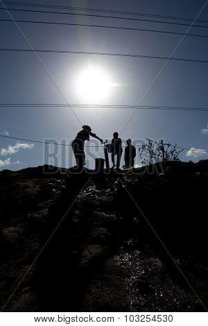 Silhouette of family getting water