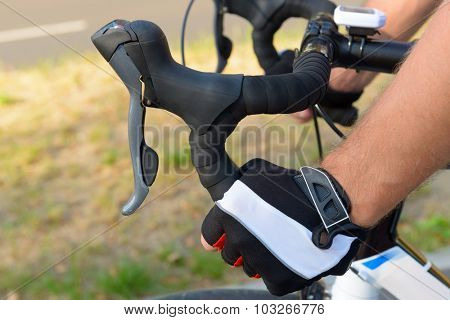 Hands in gloves on bicycle's handlebars