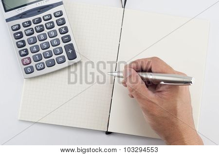 Man hand with pen writing on notepad.