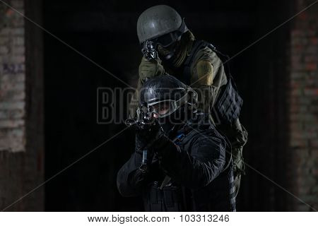 Fully equipped military men with automatic weapons playing airsoft strikeball