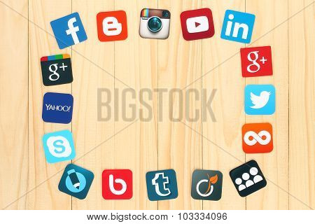 Famous social media icons placed around on wooden background