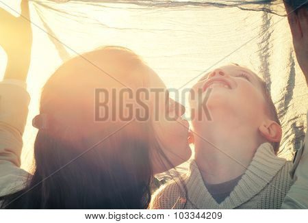Mother Kissing Her Child Druing Playing