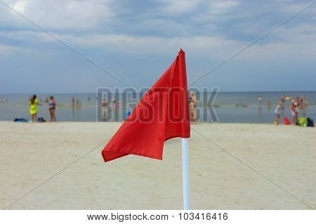 Red Flag On A Sandy Beach