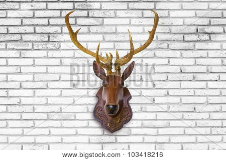 Deer Head Made Of Red Wood On Blurred White Brick Wall Background.
