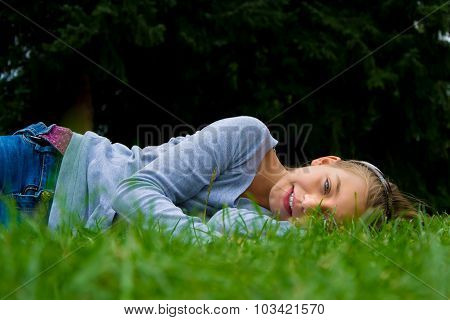 Child girl lay in grass smiling