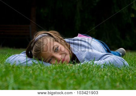 Happy child girl laying in grass