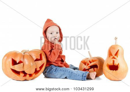 Halloveen small boy sits surrounded by pumpkins on white background