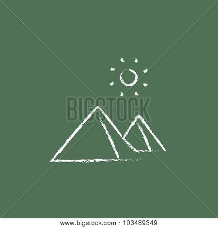 Egyptian pyramids hand drawn in chalk on a blackboard vector white icon isolated on a green background.