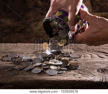caucasian old man's hands and pile of old coins