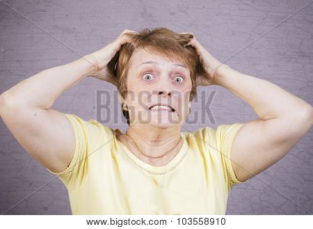 Very emotional angry woman on a gray background.