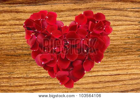 Beautiful Red Rose Petals As Heartsymbol On Wooden Background