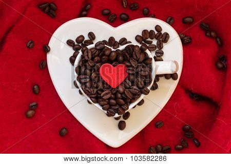 Heart Shaped Cup With Coffee Beans On Red