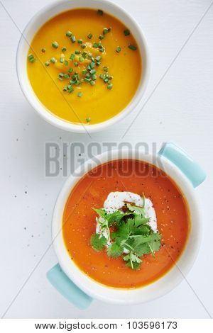 Roasted butternut pumpkin squash soup and a tomato sweet potato soup garnished with coriander and coconut milk cream