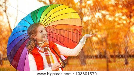 Happy Woman With Rainbow Multicolored Umbrella Under Rain In Park