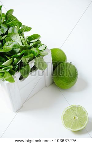 Watercress Salad In White Wooden Box With Limes Around