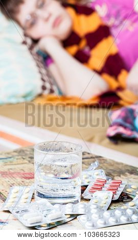 Glass With Water And Medicaments On Table