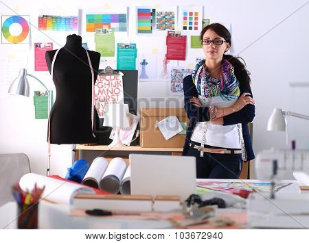 Beautiful fashion designer standing in studio