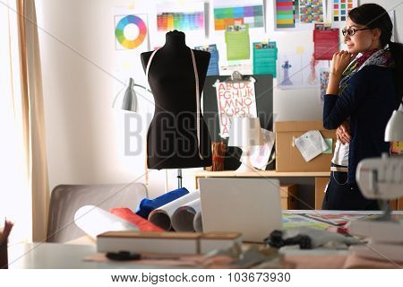 Beautiful fashion designer standing in studio