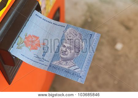 Malaysia Ringgit One Dollar Halfly Inserted Into Vending Machine With Selective Focus.