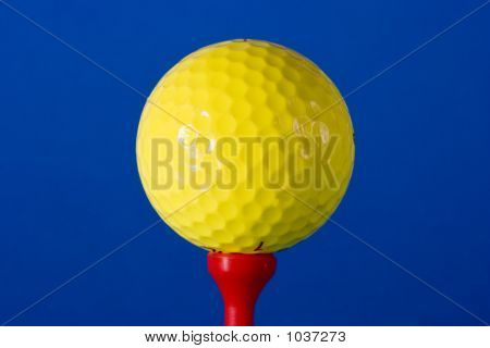 Balle de Golf jaune sur Tee rouge sur fond bleu